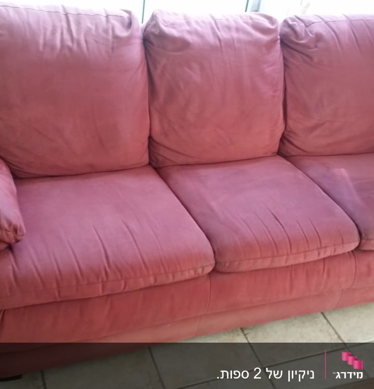 ספה אדומה עם כריות על רצפת אריחים